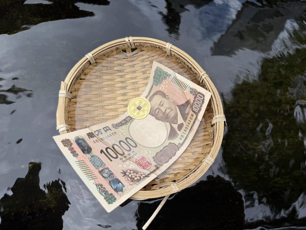 白蛇清水で銭洗いをする様子