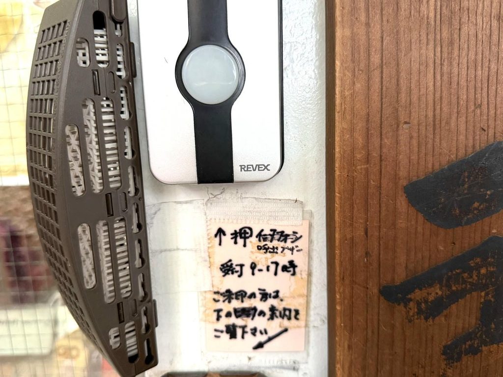 椙森神社の社務所入口にある呼び出し用インターホンと受付時間の案内